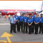 A group of people standing in front of an airplane.