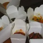 A bunch of takeout boxes filled with food