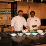 Two chefs in a kitchen preparing food for the restaurant.