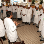 A group of chefs in white uniforms standing around.