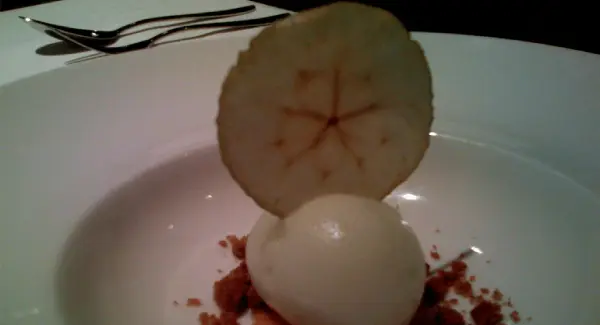 A plate with an apple and a hard boiled egg.